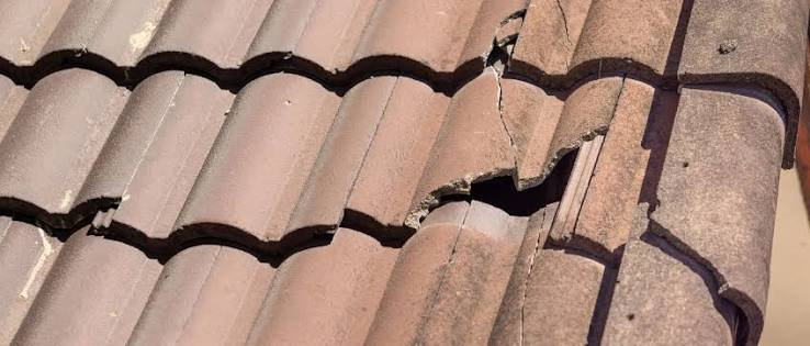 Broken and cracked curved concrete roof tiles