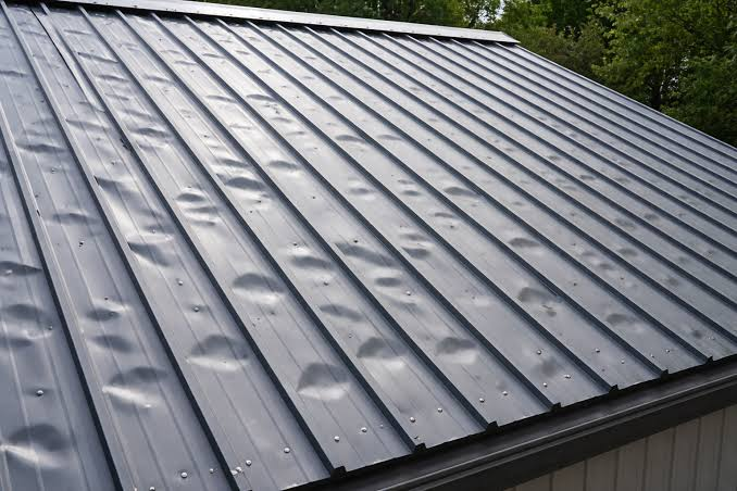 Metal roof panels covered with visible hail dents
