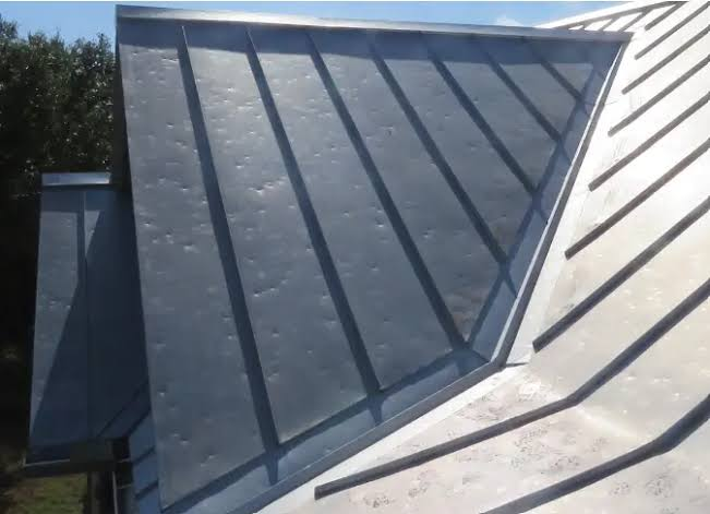 Standing-seam metal roof with visible impact dents